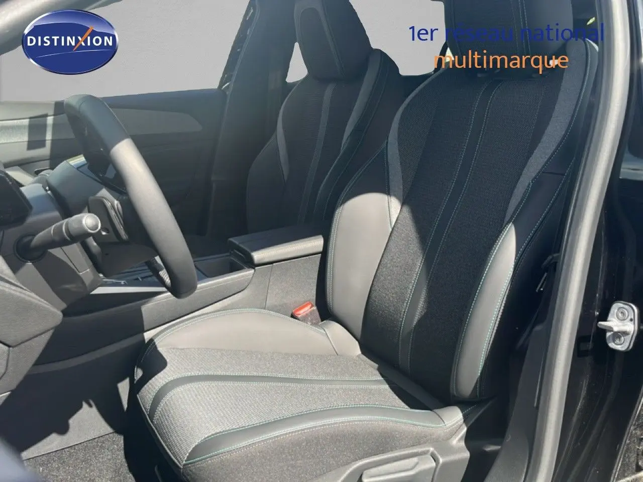 Vue intérieure côté conducteur de la Peugeot 308 Hybrid 145ch Allure 2025, sièges tissu et cuir gris noir, porte ouverte.
