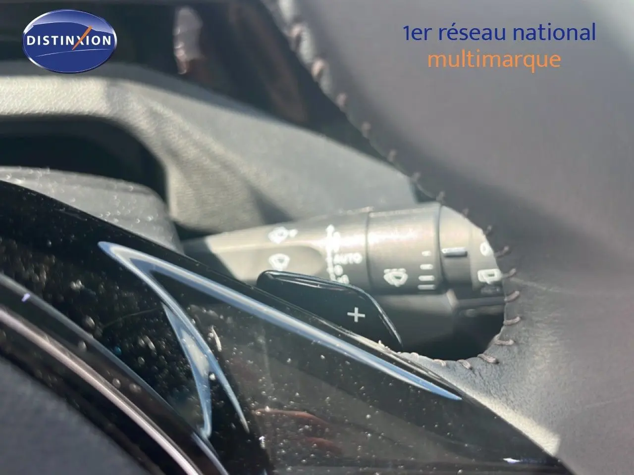 Gros plan sur la palette de changement de vitesse côté droit du volant en cuir noir de la Peugeot 308 Hybrid 2025.