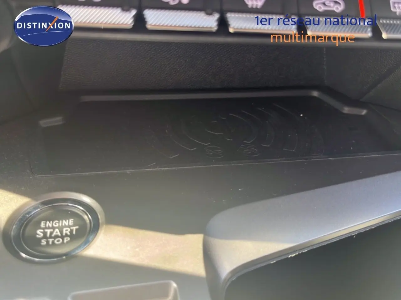 Gros plan sur le bouton start/stop et le chargeur sans fil dans l'habitacle de la Peugeot 308 noir métal.