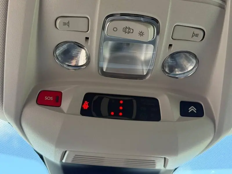 Vue en gros plan du plafonnier beige avec boutons SOS et commandes d’éclairage du Citroën C5 Aircross blanc Okénite.
