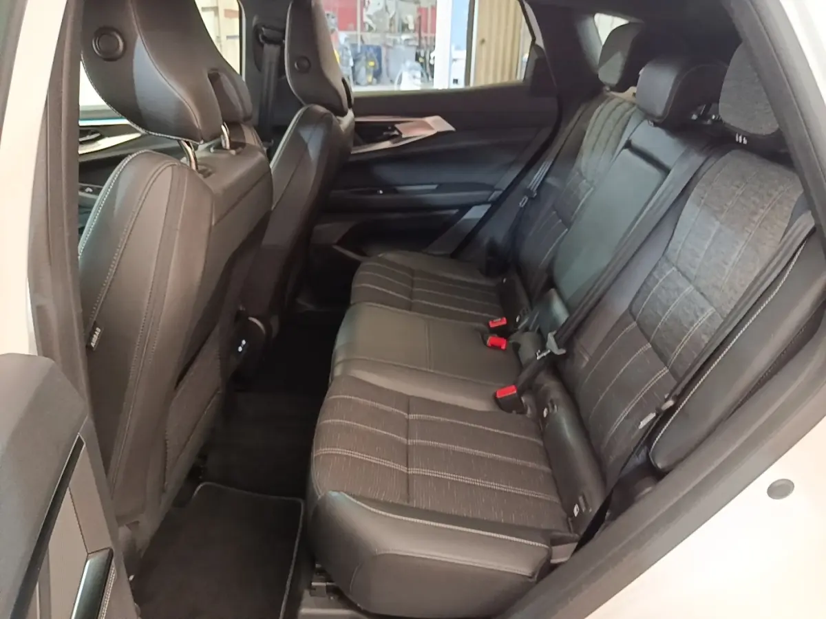 Vue intérieure côté droit montrant la banquette arrière noire avec assise fractionnée du Renault Austral blanc 2023.