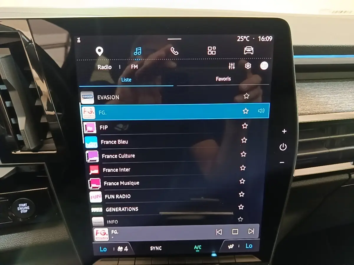 Écran tactile central de la Renault Austral blanc, affichant la liste des stations radio avec commandes visibles.