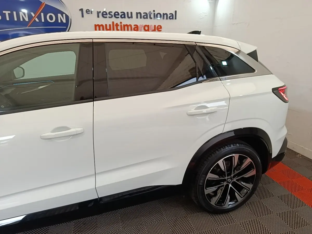Vue côté droit arrière du Renault Austral blanc hybride 2023 avec jantes alliage et vitres teintées.