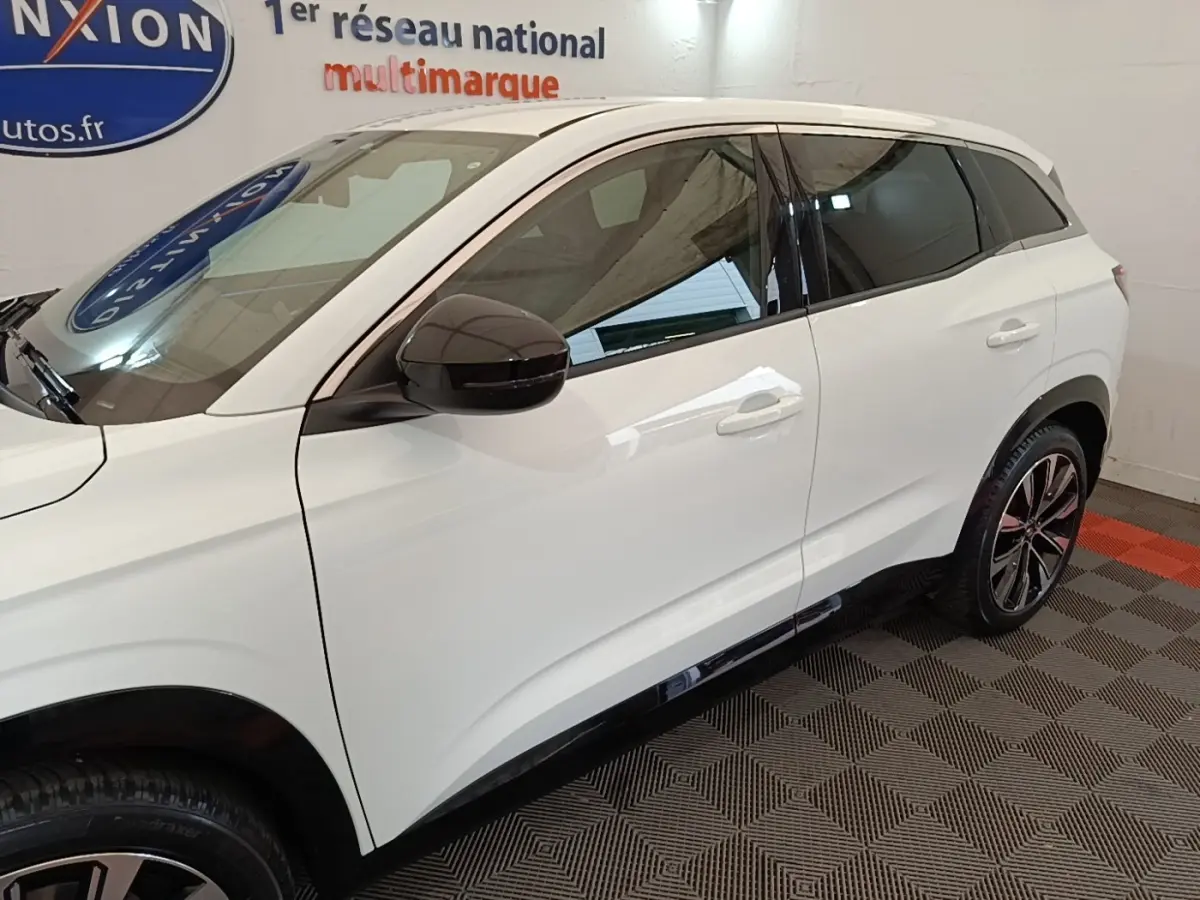 Vue de profil côté gauche du Renault Austral blanc 2023 avec jantes alliage et rétroviseurs noirs.