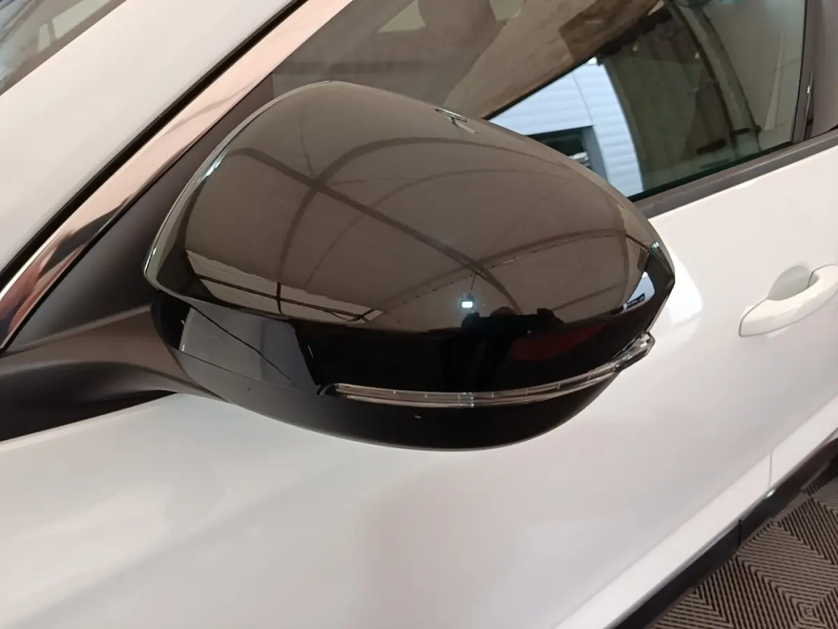 Rétroviseur droit noir brillant du Renault Austral blanc, vue rapprochée sur la portière côté droit.