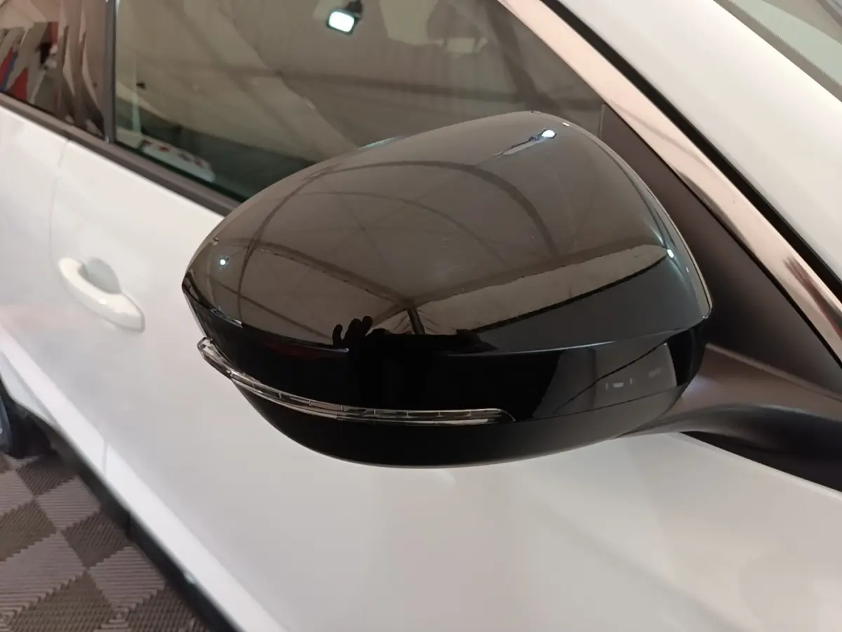 Rétroviseur noir en gros plan côté gauche sur Renault Austral blanc, avec clignotant intégré visible.
