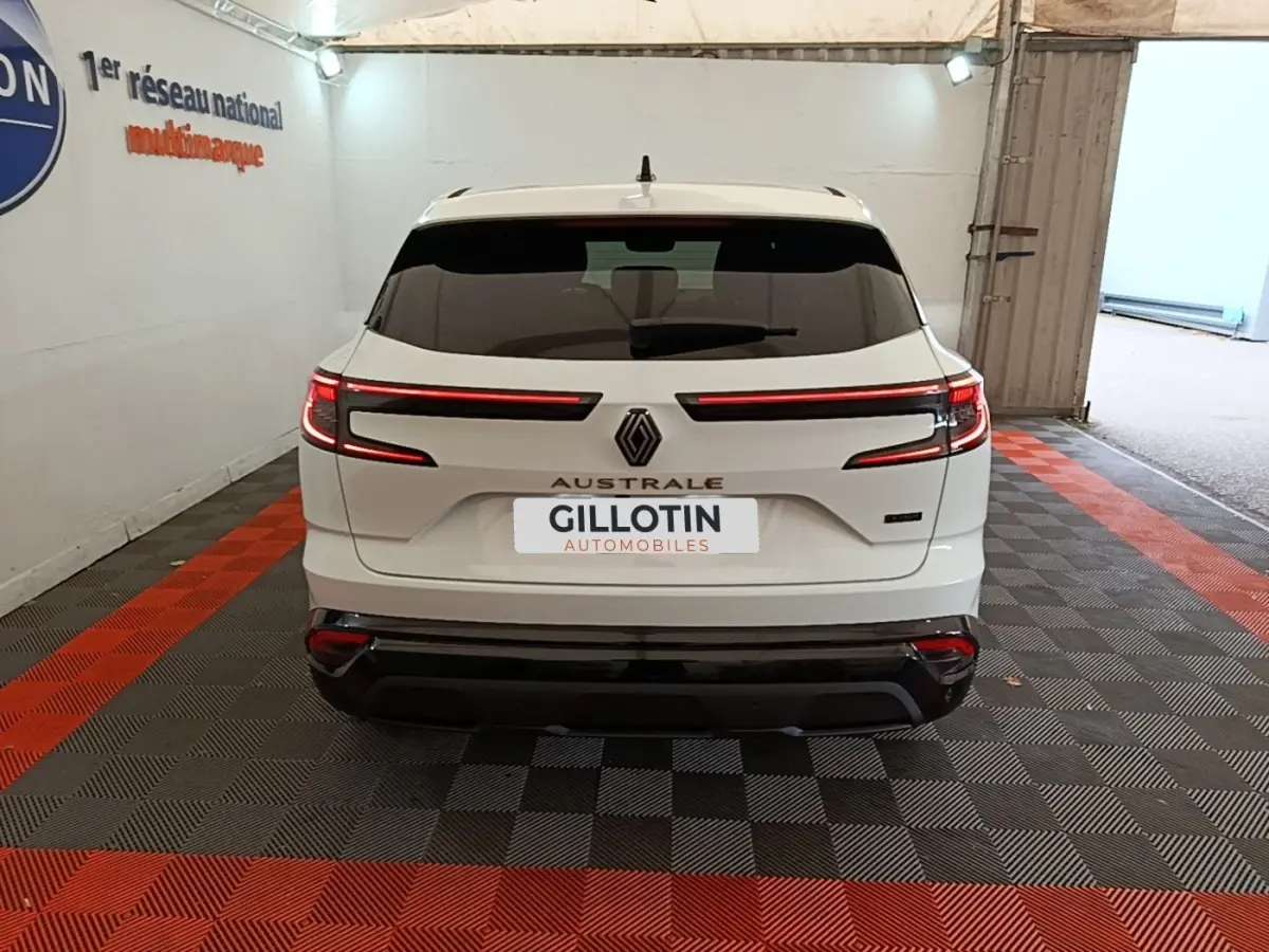 Vue arrière d'un Renault Austral blanc 2023 avec feux LED horizontaux et logo central dans un garage.