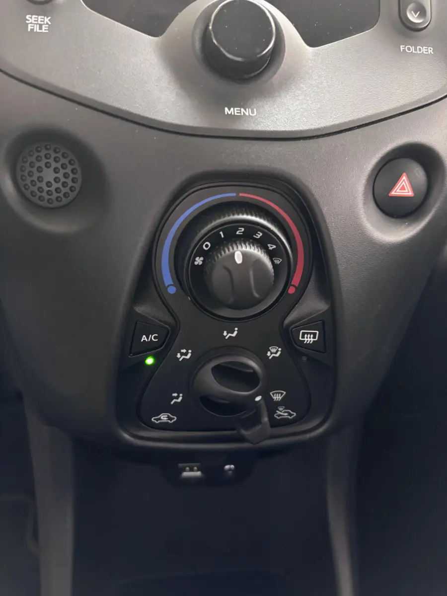 Gros plan sur les commandes de climatisation noire du tableau de bord de la Toyota Aygo gris foncé 2020.