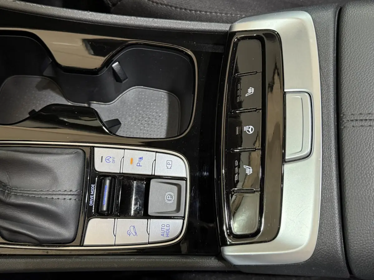 Gros plan sur la console centrale noire du Hyundai Tucson 2021 avec commandes de conduite et sièges chauffants.