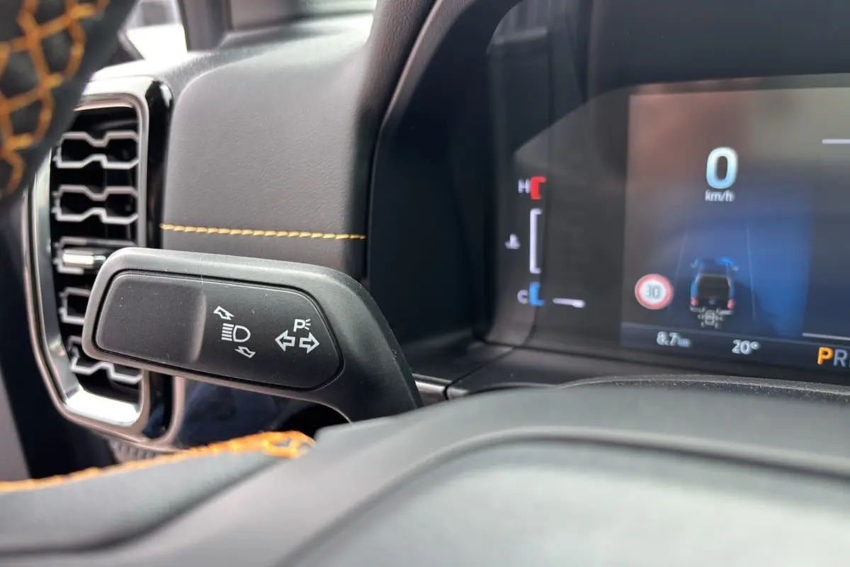 Détail intérieur du Ford Ranger 2025 Wildtrak Plus, montrant la commande de clignotants et le tableau de bord numérique.