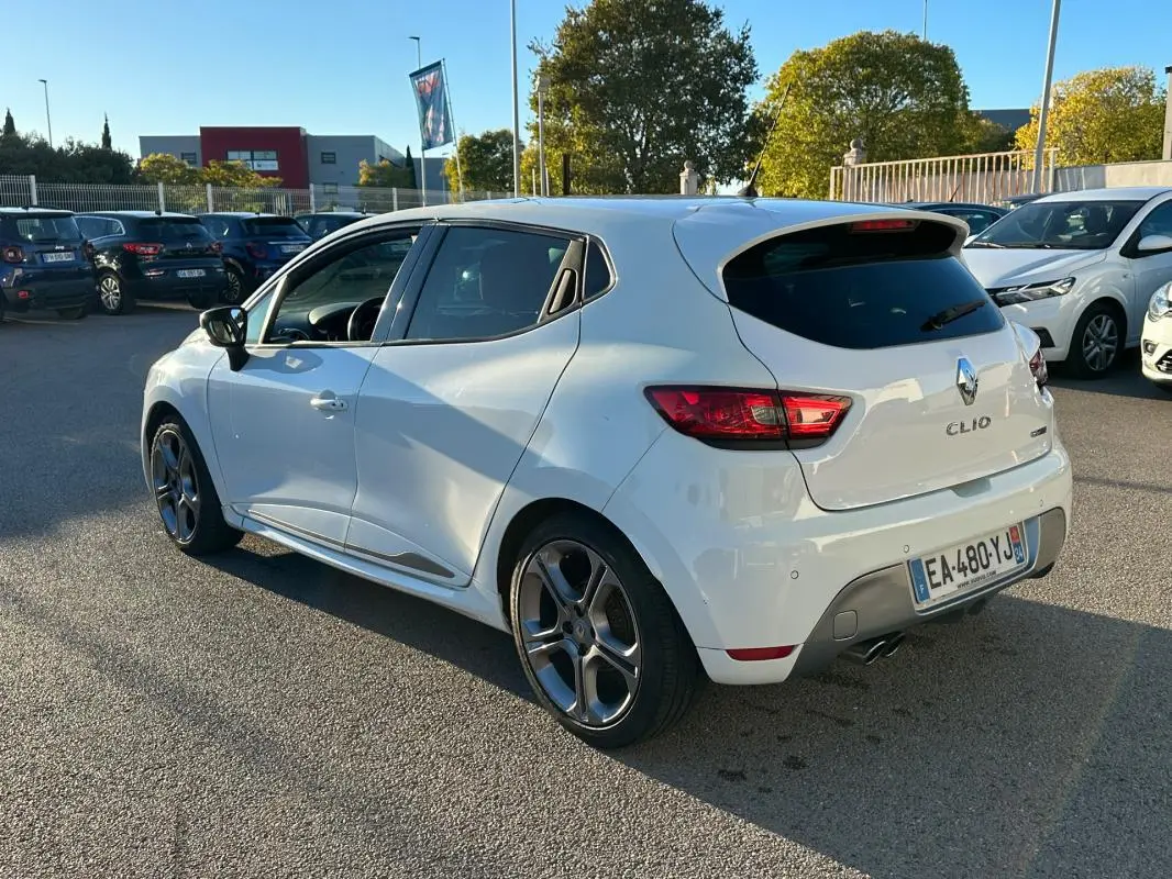 Renault Clio IV TCe 120 GT blanc vue 3/4 arrière droit avec jantes alliage 17 pouces et vitres surteintées.