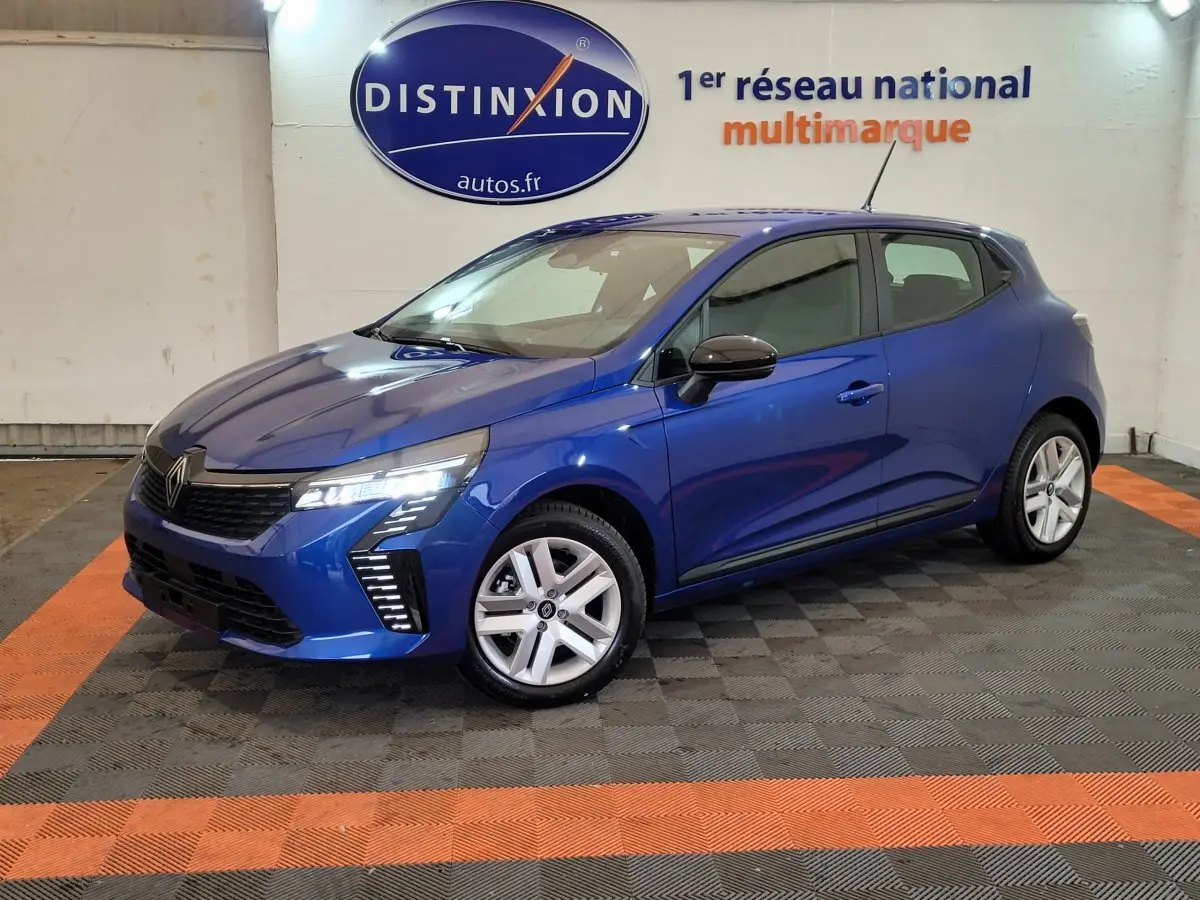 Renault Clio Evolution Blue dCi 100 2025 bleu, vue 3/4 avant droit avec phares LED allumés en intérieur showroom
