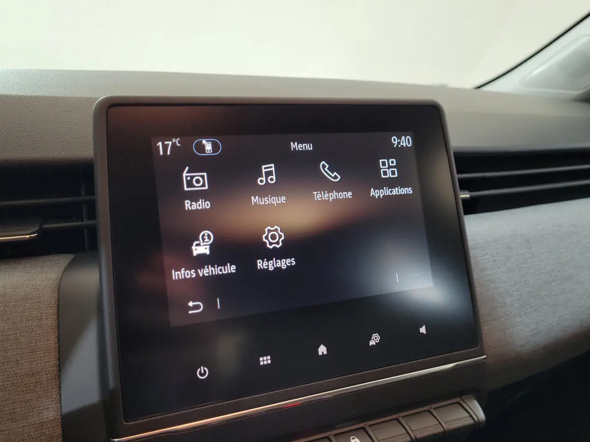 Écran tactile central de la Renault Clio 2025 affichant le menu principal avec options radio, musique et téléphone.