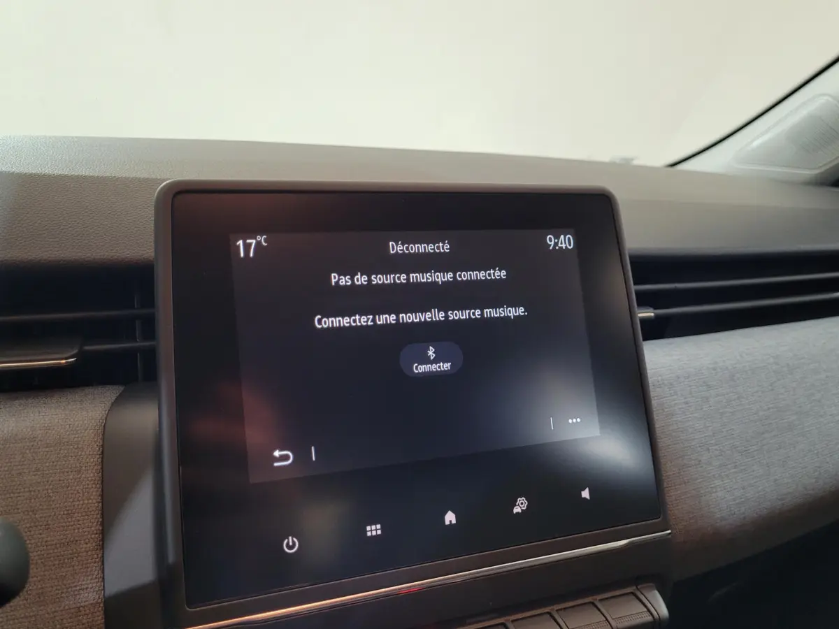 Écran tactile central du tableau de bord de la Renault Clio bleu 2025 affichant un message de connexion Bluetooth.