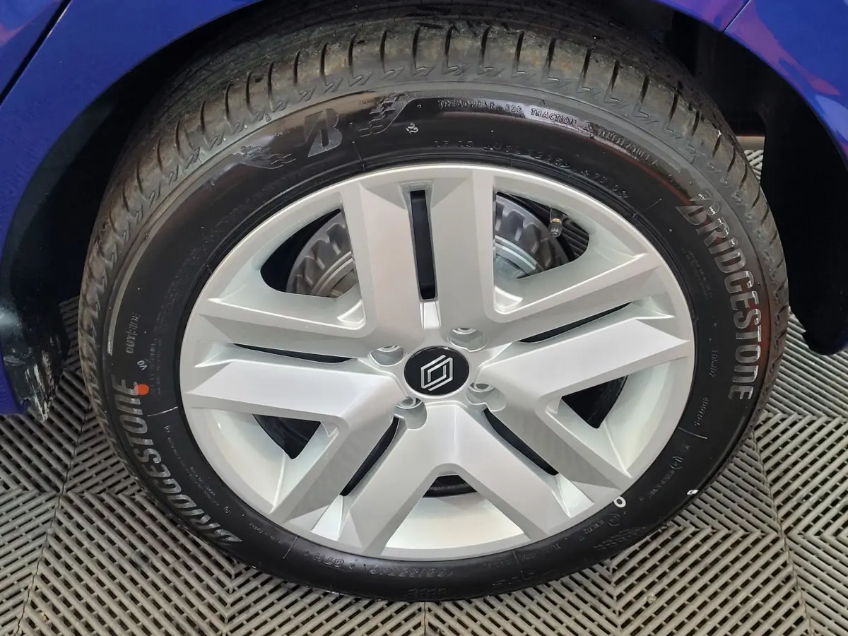 Gros plan sur la roue avant droite d'une Renault Clio bleu 2025 avec pneu Bridgestone visible.