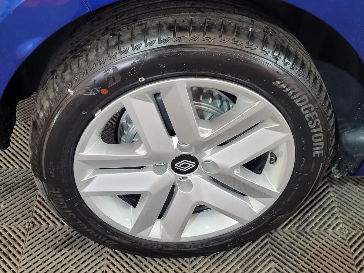 Gros plan sur la roue avant droite d'une Renault Clio bleu 2025 avec jante argentée et pneu Bridgestone.