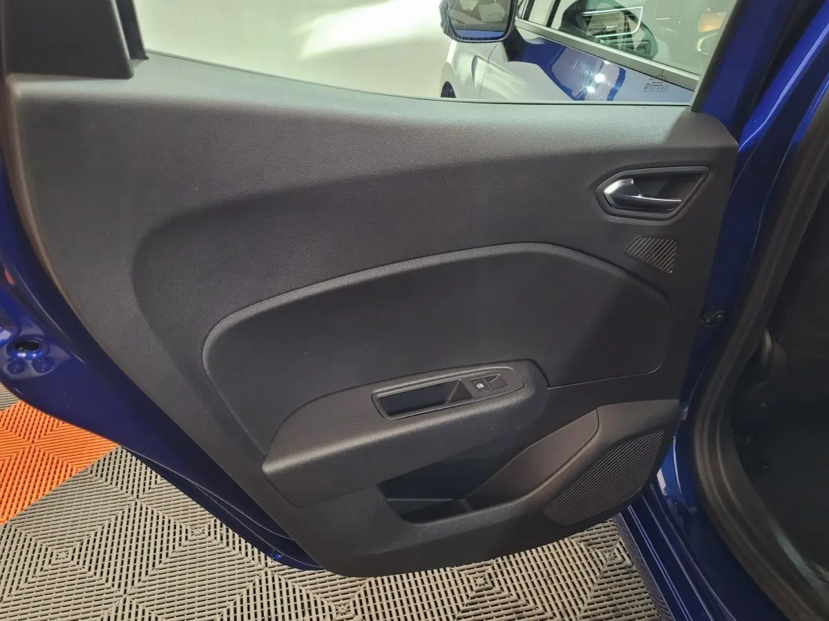 Porte intérieure côté gauche de la Renault Clio bleu 2025, avec commande de fenêtre et haut-parleur intégré.