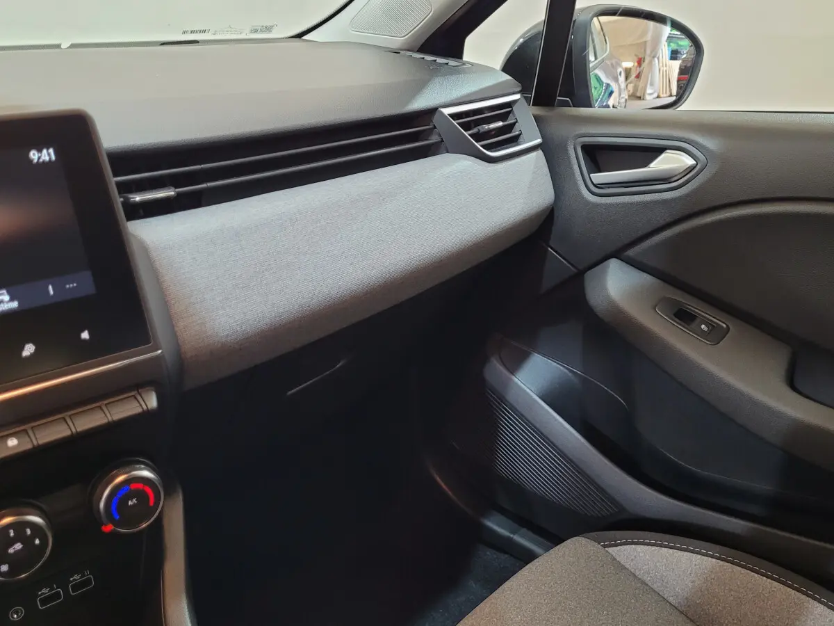 Intérieur de la Renault Clio Evolution Blue dCi 100 2025, vue côté passager avec tableau de bord gris clair et écran tactile.