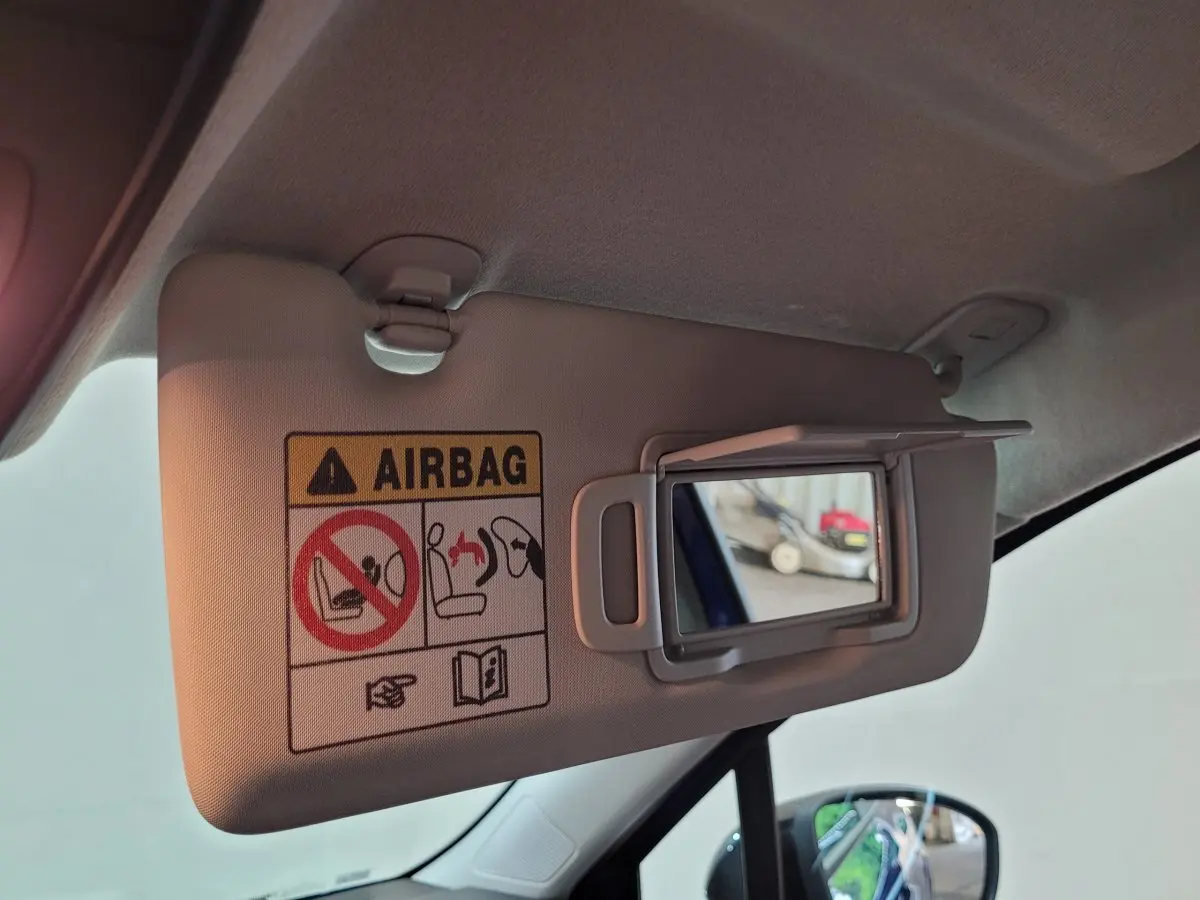 Détail du pare-soleil côté conducteur avec miroir et avertissement airbag dans une Renault Clio bleu 2025.