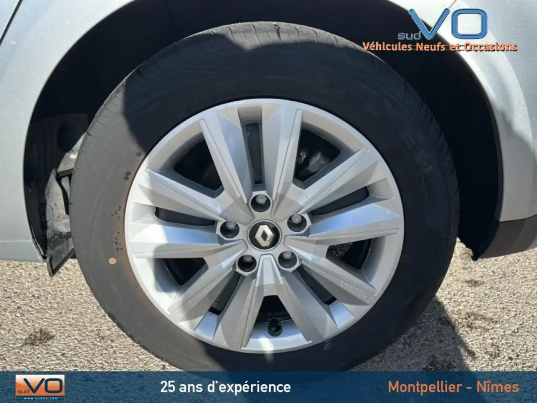 Gros plan sur la jante 16 pouces argentée avec logo Renault d'une Renault Mégane IV gris clair, côté avant droit.