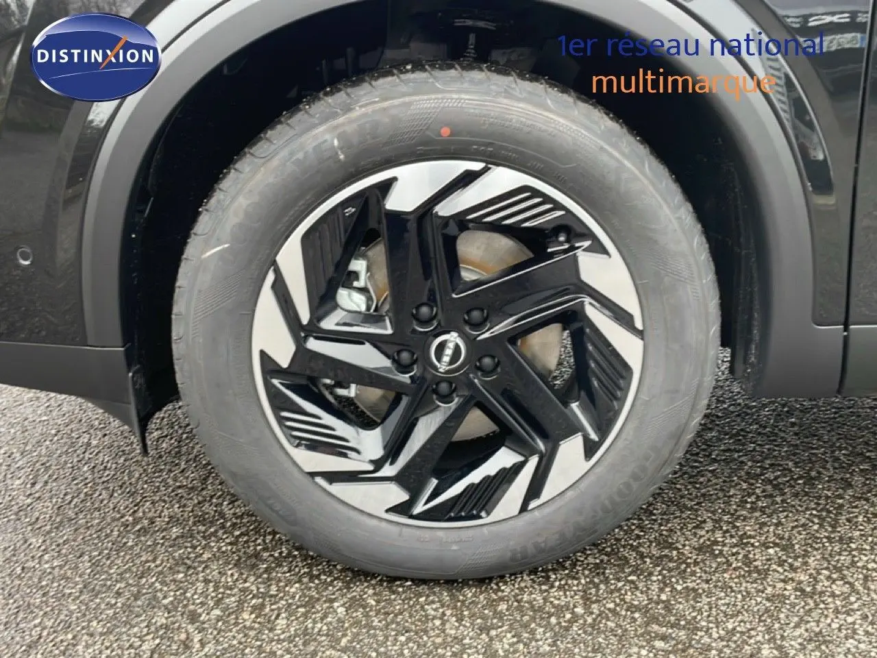 Gros plan sur la roue avant droite du Nissan Qashqai noir perle métal avec jante alliage noire et argentée design moderne.