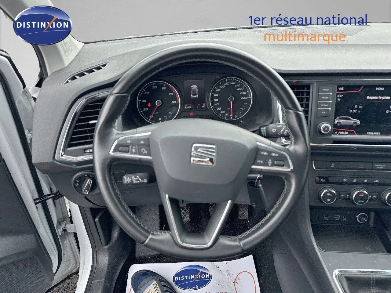 Vue intérieure centrée sur le volant du SEAT Ateca blanc Nevada 2018 avec tableau de bord et écran multimédia visible.