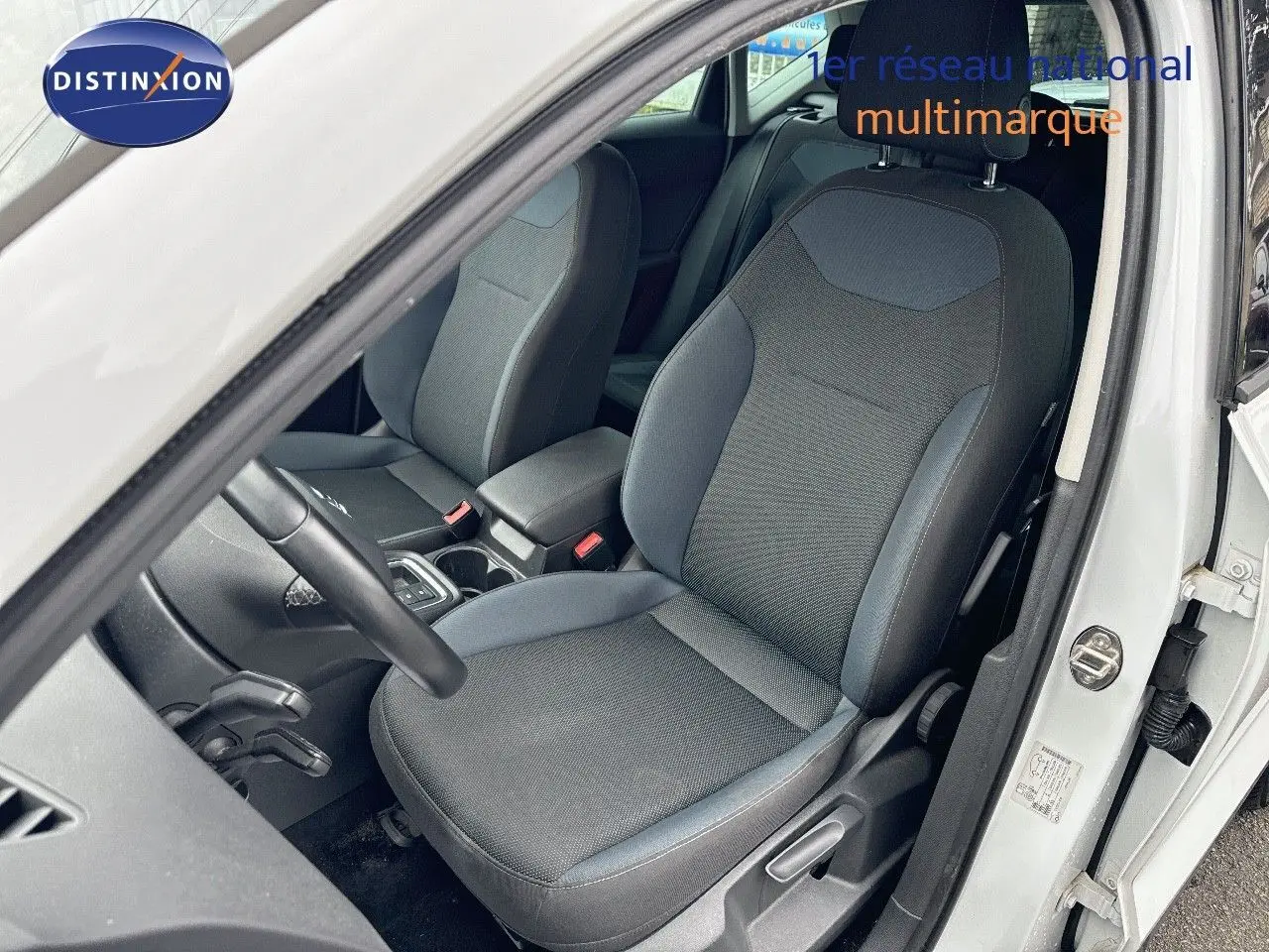 Vue intérieure côté conducteur du SEAT ATECA blanc Nevada 2018, mettant en valeur le siège avant en tissu gris.