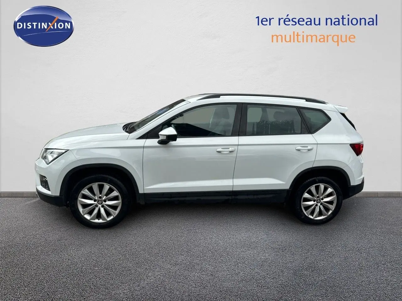 Profil côté gauche d'un SUV SEAT Ateca blanc Nevada 2018, version Style Plus avec jantes alliage et toit noir.