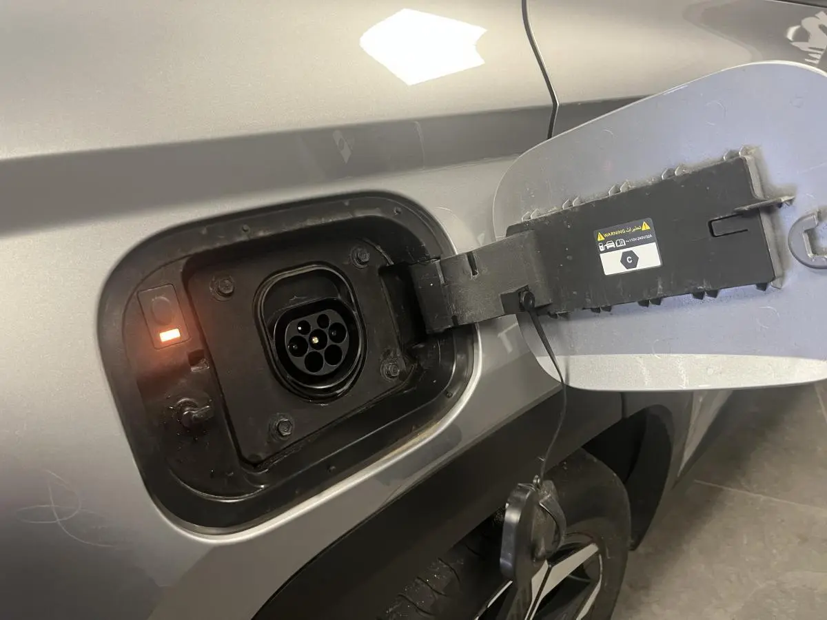 Prise de recharge ouverte côté gauche sur un Hyundai Tucson gris métallisé 2023 hybride rechargeable.