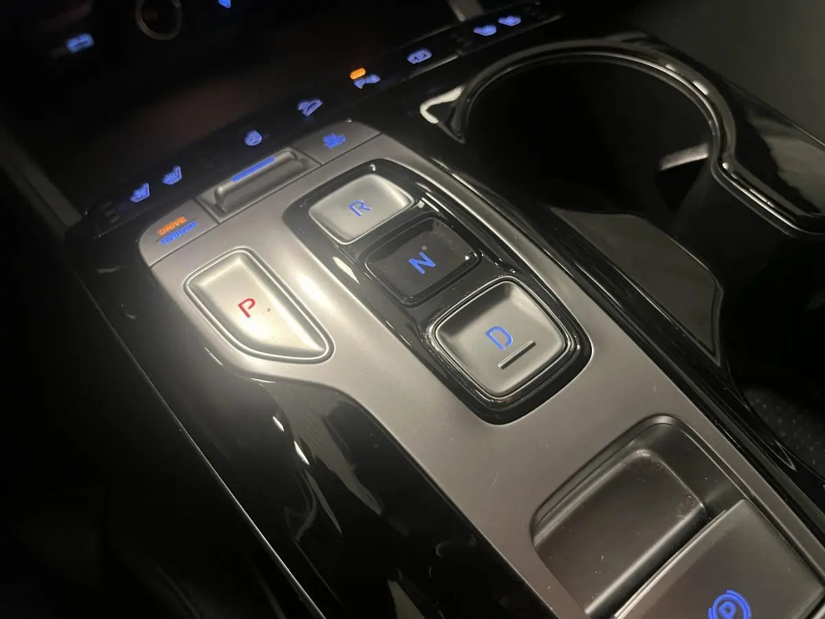 Console centrale du Hyundai Tucson 2023 hybride rechargeable, avec boutons de sélection de vitesse P, R, N, D éclairés.