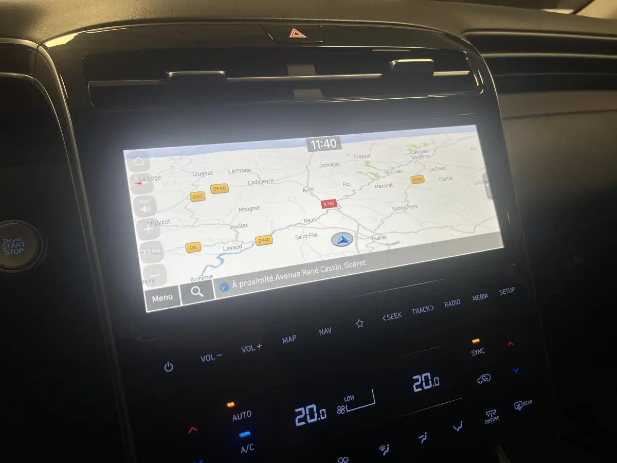 Vue rapprochée de l’écran tactile central du Hyundai Tucson 2023 affichant la navigation GPS et commandes climatisation.