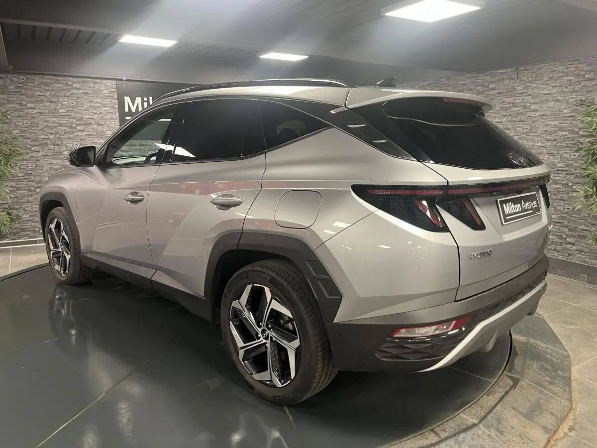 Vue 3/4 arrière droite du Hyundai Tucson gris métallisé avec jantes alliage 19 pouces et toit noir contrasté.