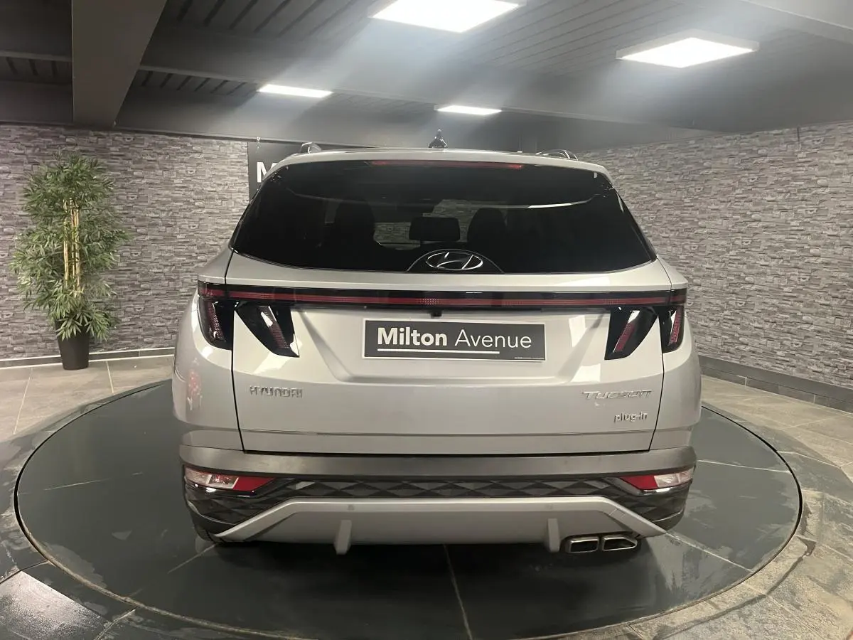 Vue arrière d'un Hyundai Tucson gris métallisé 2023 avec feux arrière LED et double sortie d'échappement.