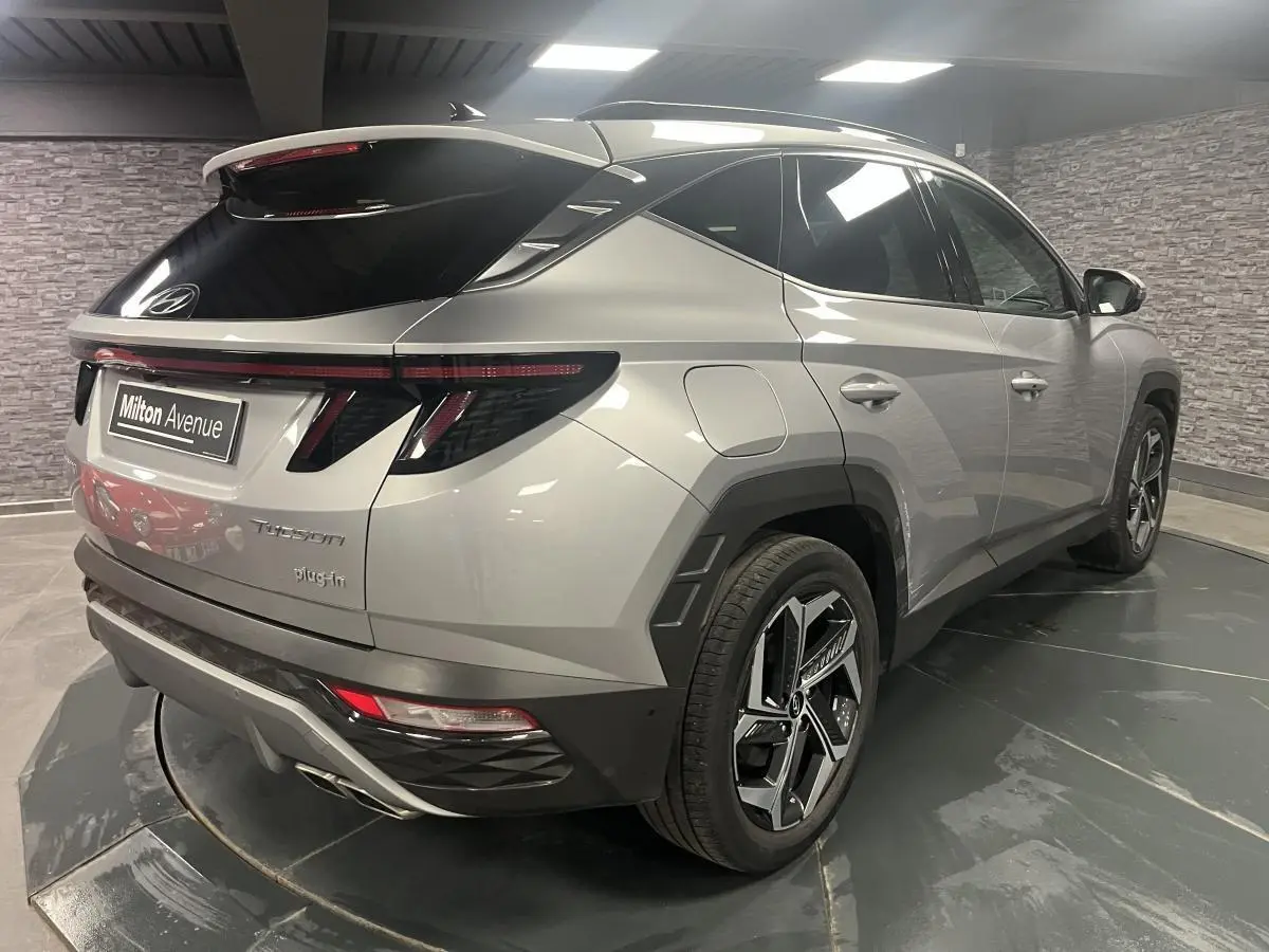 Vue 3/4 arrière droite du Hyundai Tucson gris métallisé avec feux arrière à LED et jantes alliage 19 pouces.