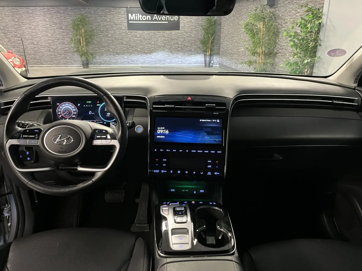 Intérieur noir du Hyundai Tucson 2023 vu de face, avec tableau de bord numérique et large écran tactile central.