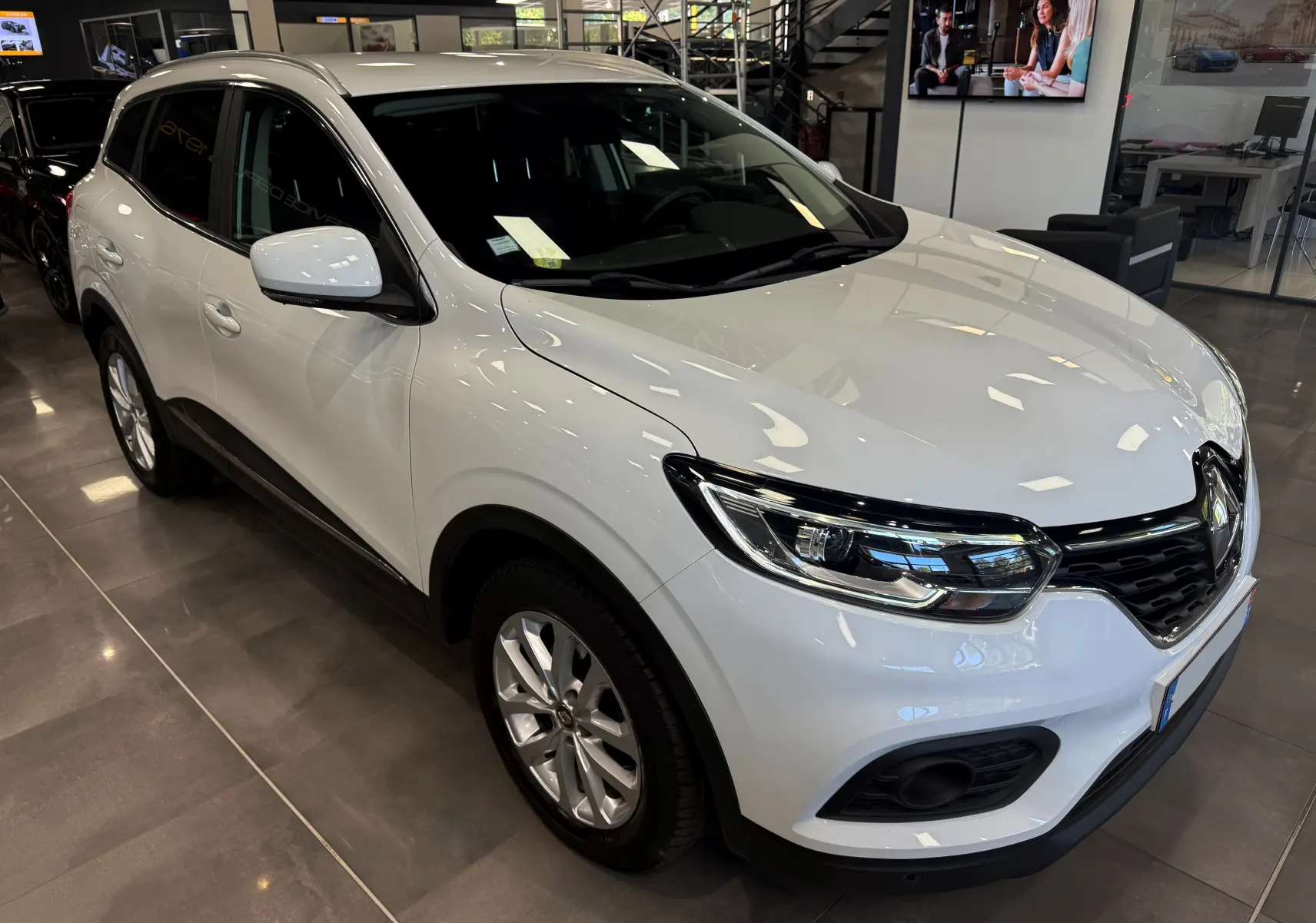 Renault Kadjar blanc glacier en 3/4 avant droit, SUV compact avec calandre noire et jantes alliage 17 pouces.