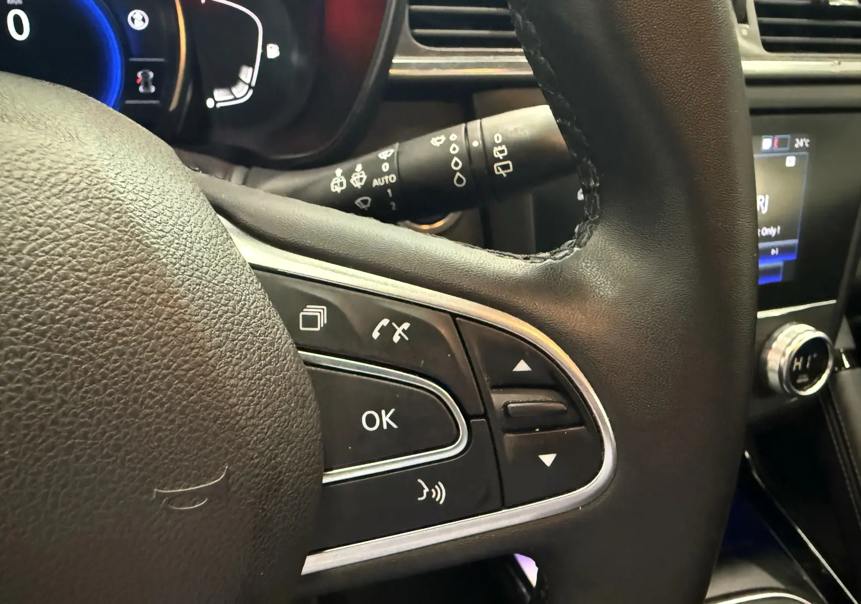 Gros plan sur le volant noir du Renault Kadjar 2020 avec commandes intégrées et tableau de bord digital bleu.