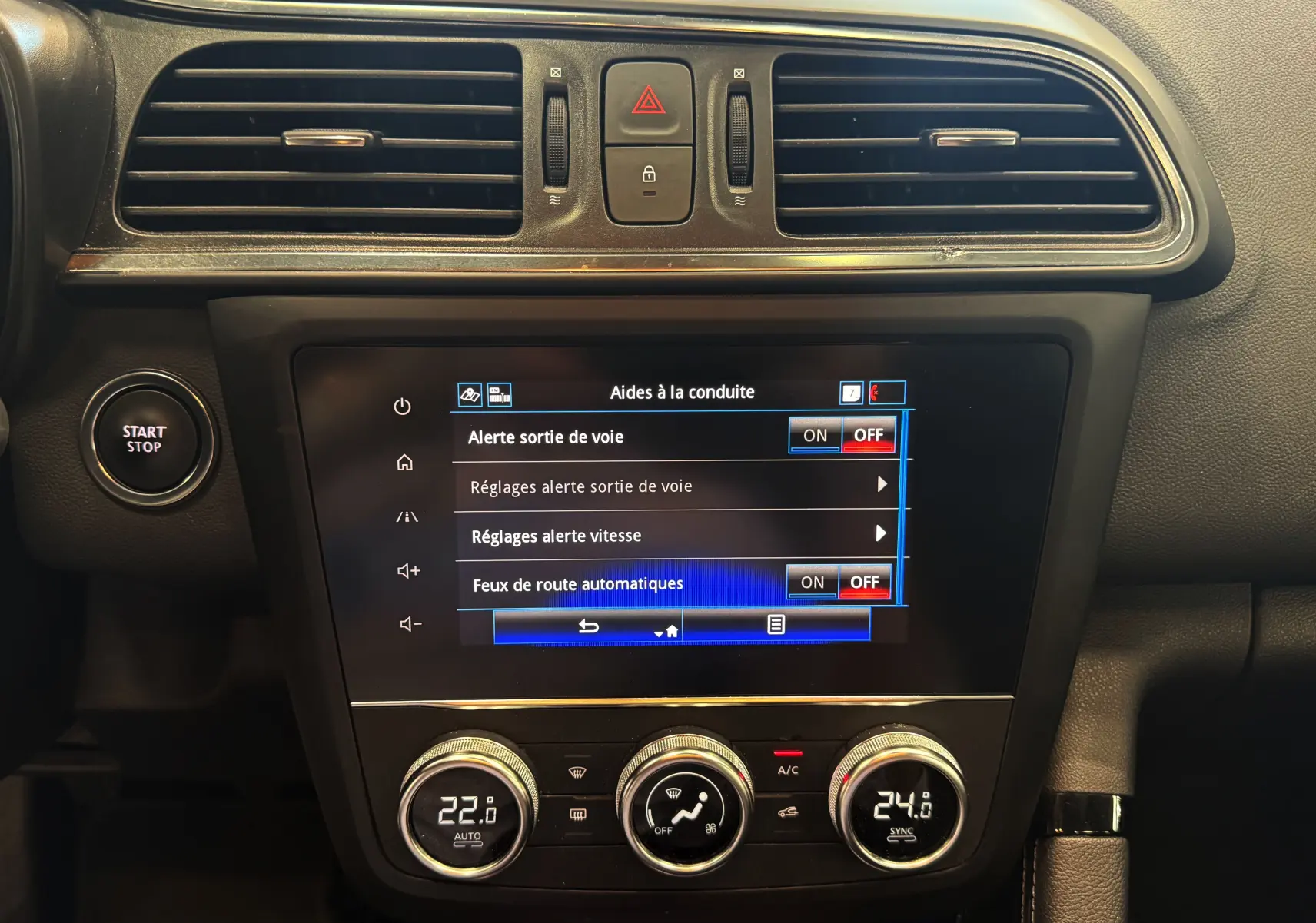 Tableau de bord du Renault Kadjar blanc, vue centrale sur l'écran tactile et commandes climatisation avec bouton Start/Stop.