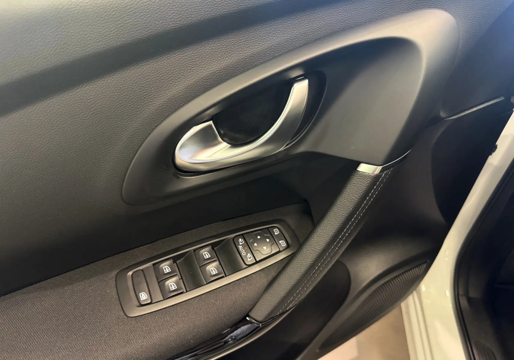 Gros plan sur la poignée intérieure et les commandes des vitres côté conducteur du Renault Kadjar Blanc Glacier 2020.