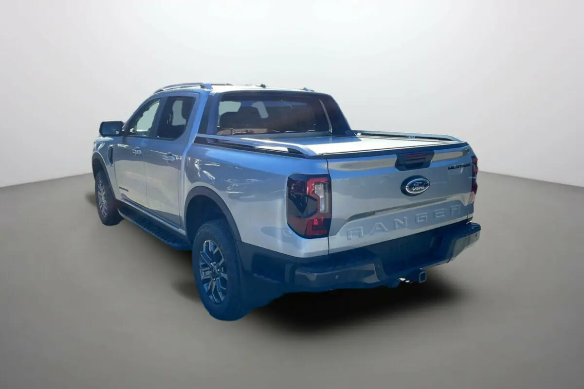 Ford Ranger 2025 gris iconic en 3/4 arrière droit, pick-up avec benne couverte et jantes spécifiques Wildtrak Plus.