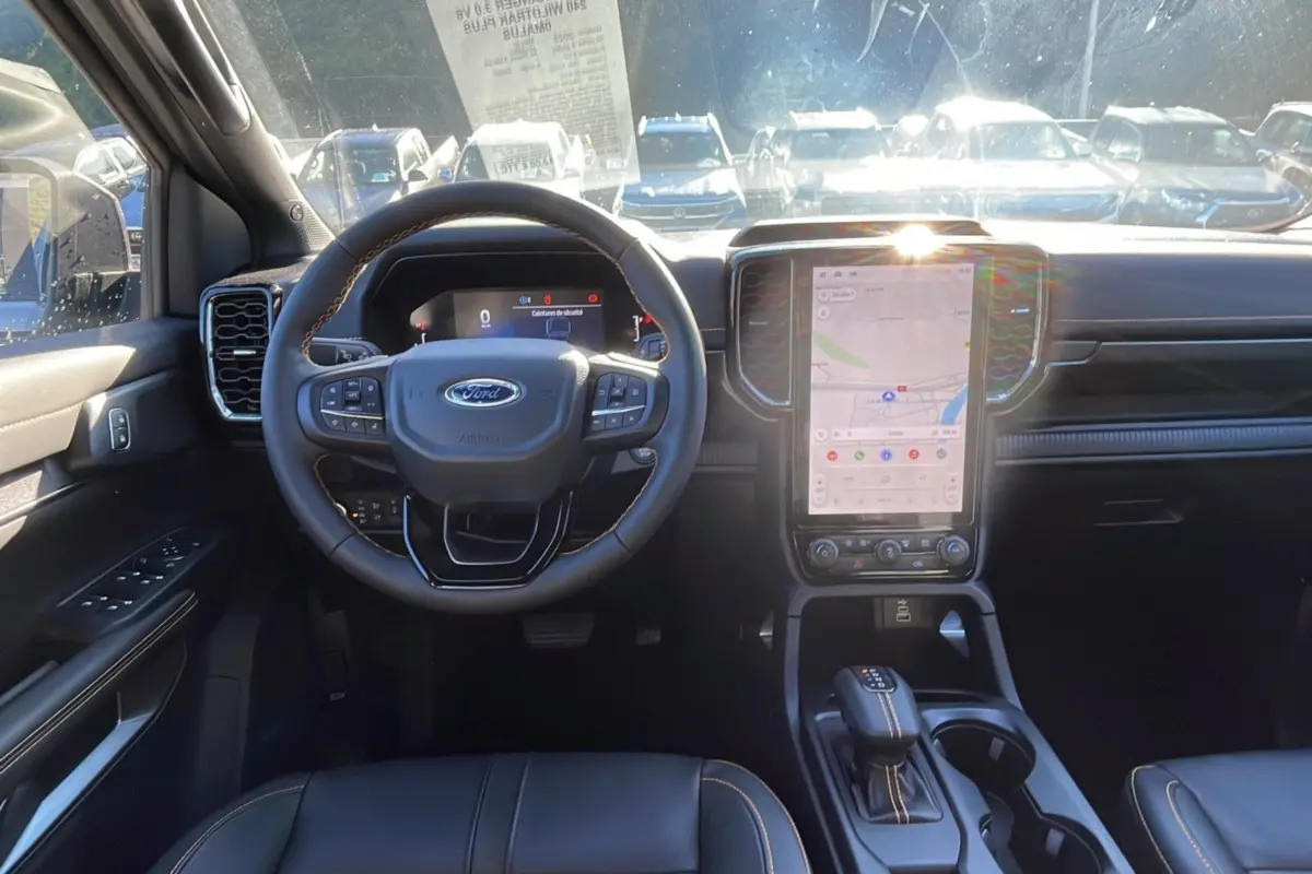 Vue intérieure frontale du Ford Ranger 2025 gris iconic, mettant en valeur le volant multifonction et l'écran tactile vertical central.