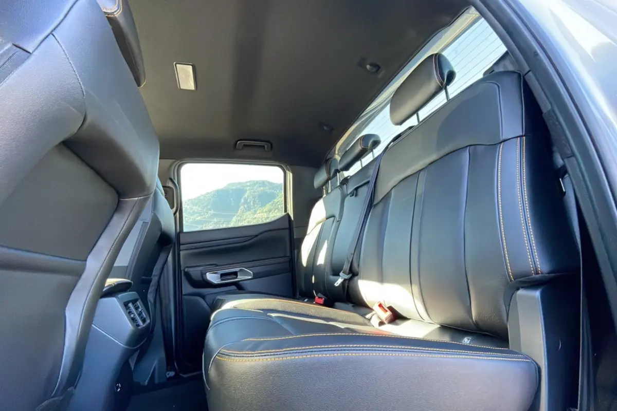 Vue intérieure arrière du Ford Ranger 2025 gris iconic, mettant en valeur les sièges en cuir noir avec surpiqûres orange.
