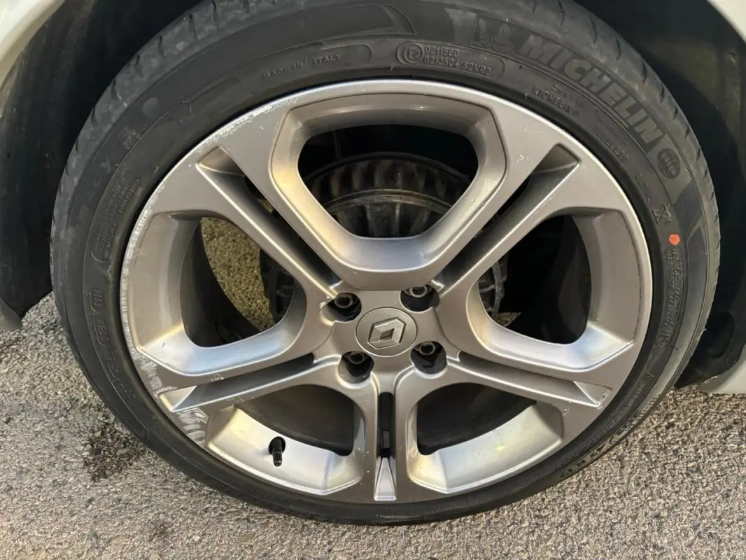 Gros plan sur la jante alliage 17 pouces gris clair d'une Renault Clio IV Estate TCe 120 GT EDC avec logo central.