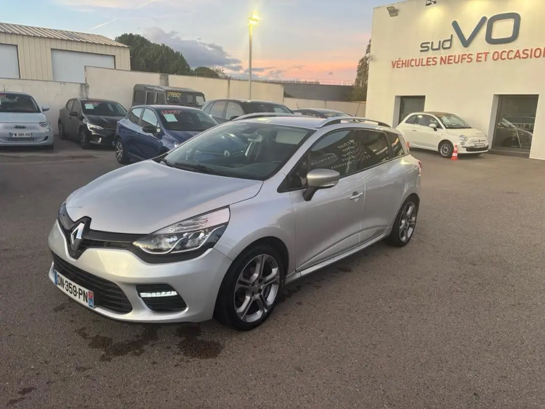 Renault Clio IV Estate gris clair vue 3/4 avant droit, jantes alliage 17 pouces et vitres surteintées visibles.