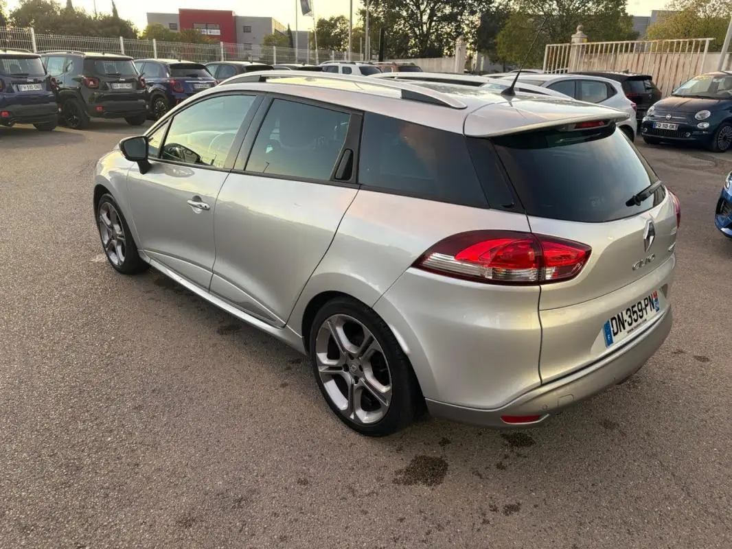 Vue 3/4 arrière droite d'une Renault Clio IV Estate gris clair avec jantes alliage 17 pouces et vitres surteintées.