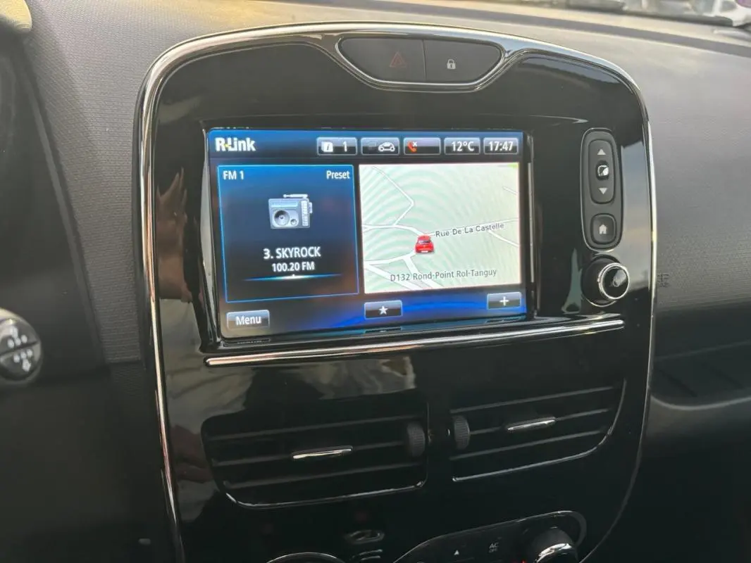 Écran tactile central R-Link avec navigation et radio, tableau de bord noir brillant de Renault Clio IV Estate gris clair.