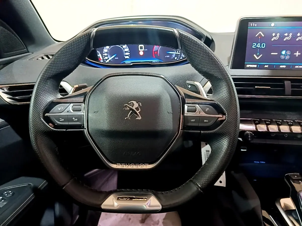 Vue intérieure centrée sur le volant cuir multifonctions du Peugeot 3008 GT Line avec tableau de bord digital.