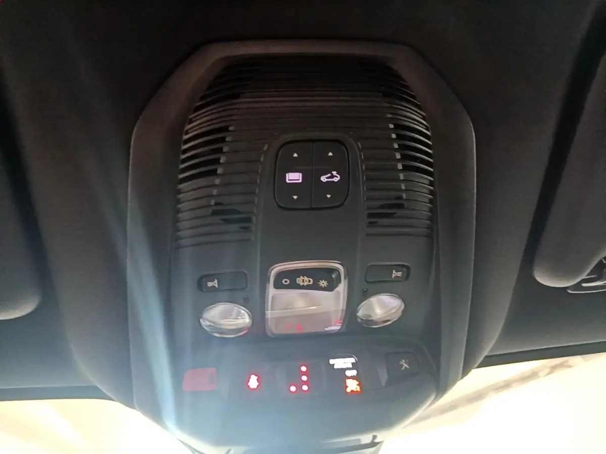 Vue intérieure en gros plan du plafonnier avec commandes d’éclairage et alertes du Peugeot 3008 gris foncé.