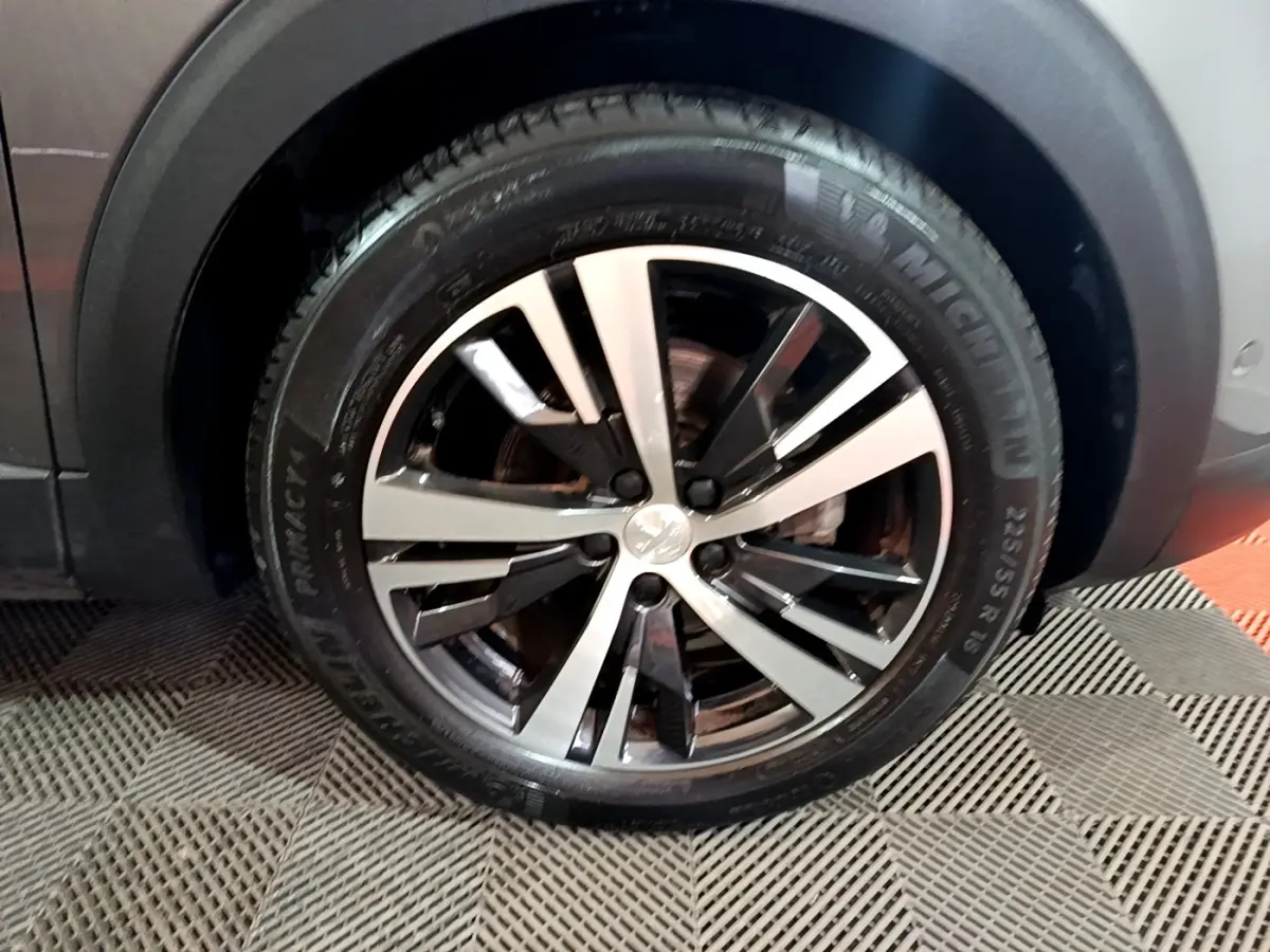 Gros plan sur la roue avant droite avec jante alliage bicolore du Peugeot 3008 gris foncé GT LINE 2020.