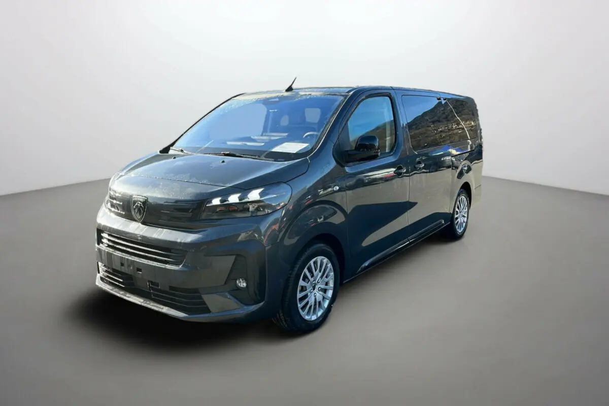 Peugeot Traveller gris titane en 3/4 avant droit, avec jantes tôle et vitres surteintées.